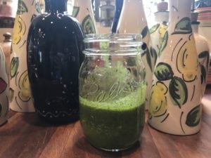 Green sauce in a mason jar with I See Spain cruets standing tall in the background