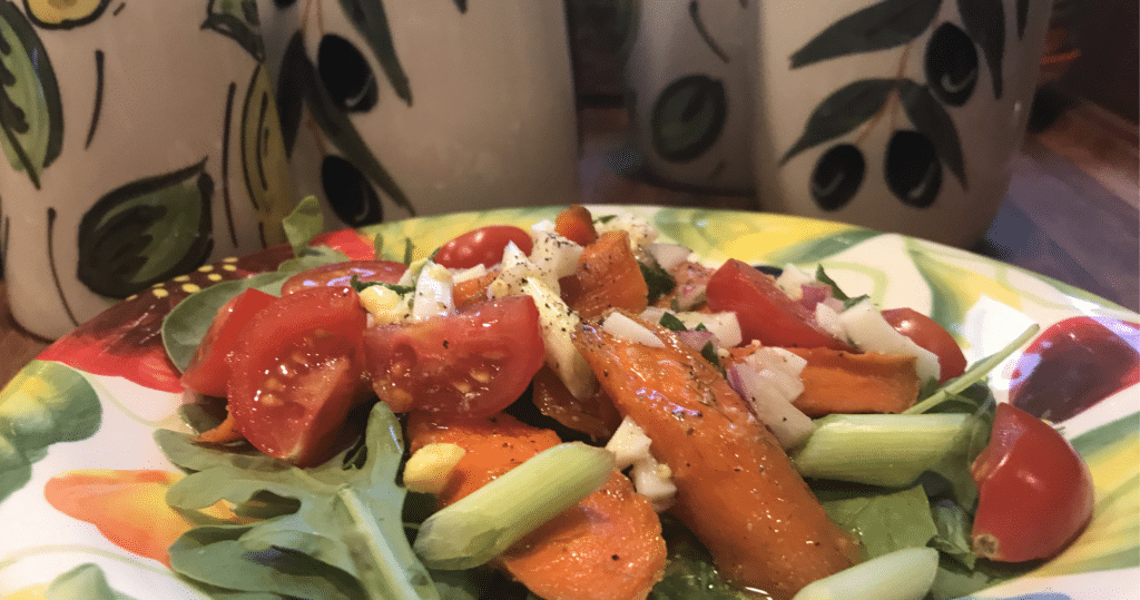 Spanish Vinaigrette served atop a garden salad on I See Spain dinnerware with cruets standing in the background